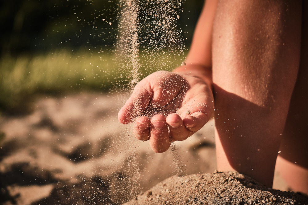 Main d'enfant touchant du sable